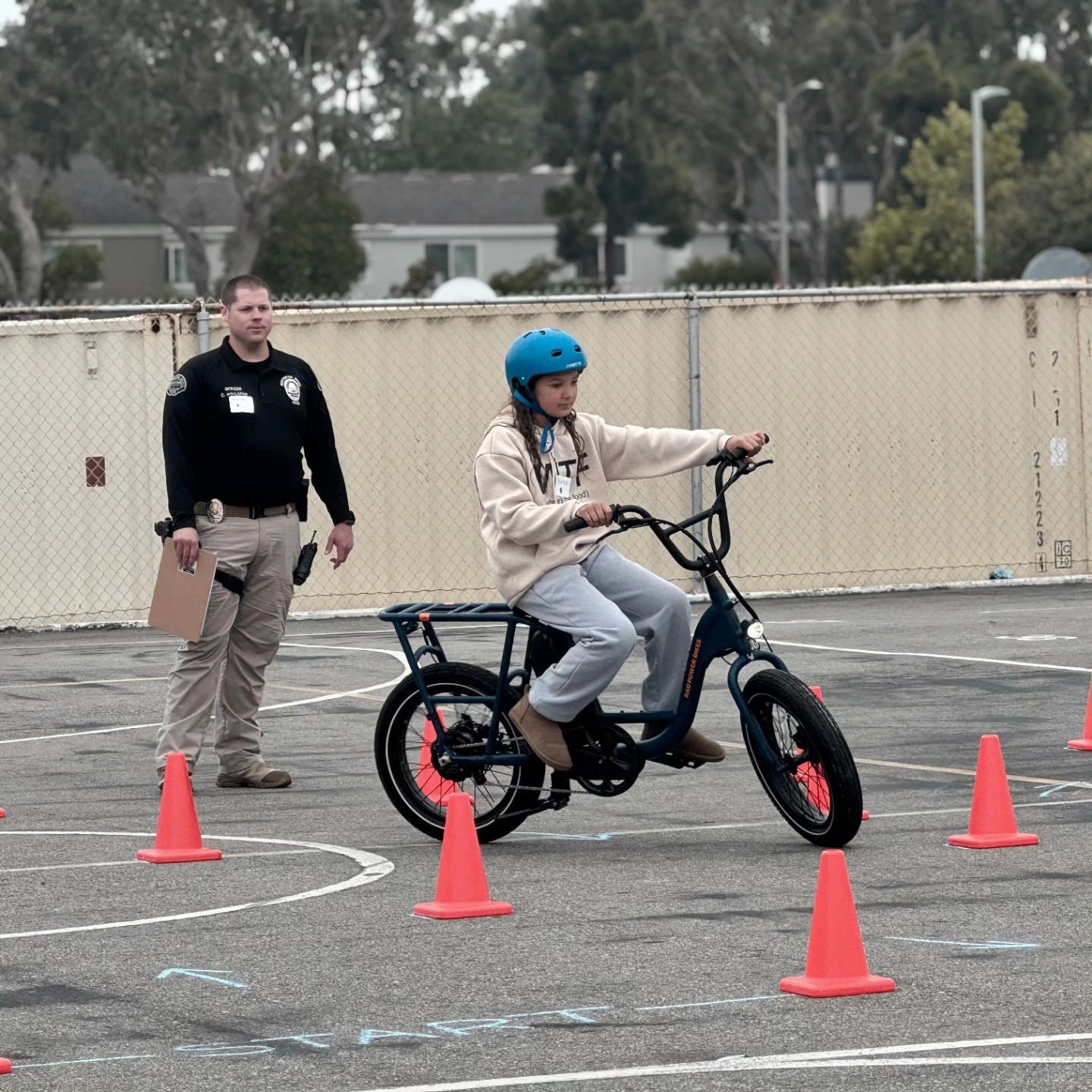 Young rider participating in VoltVerified eBike training while an officer observes nearby