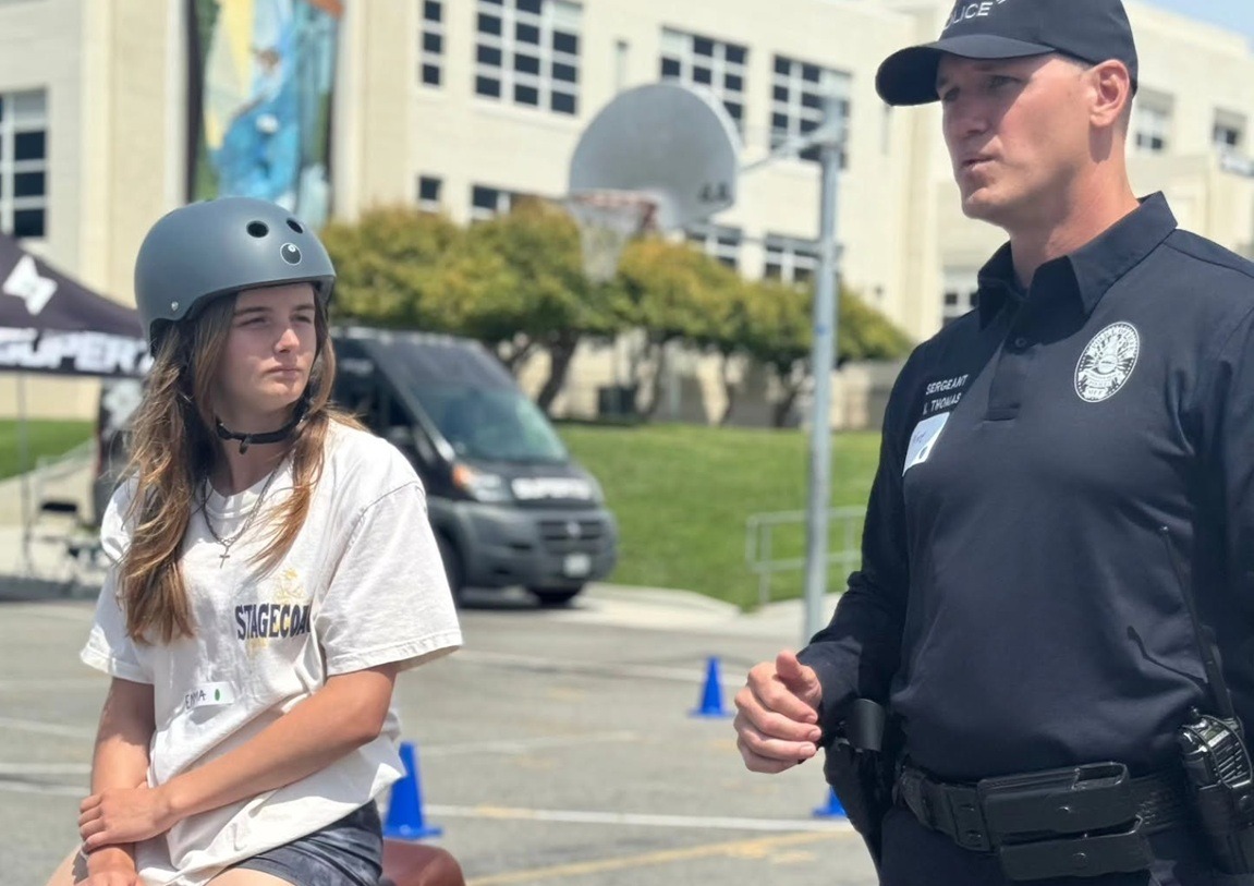 Law enforcement instructor speaking with a young rider during eBike safety training