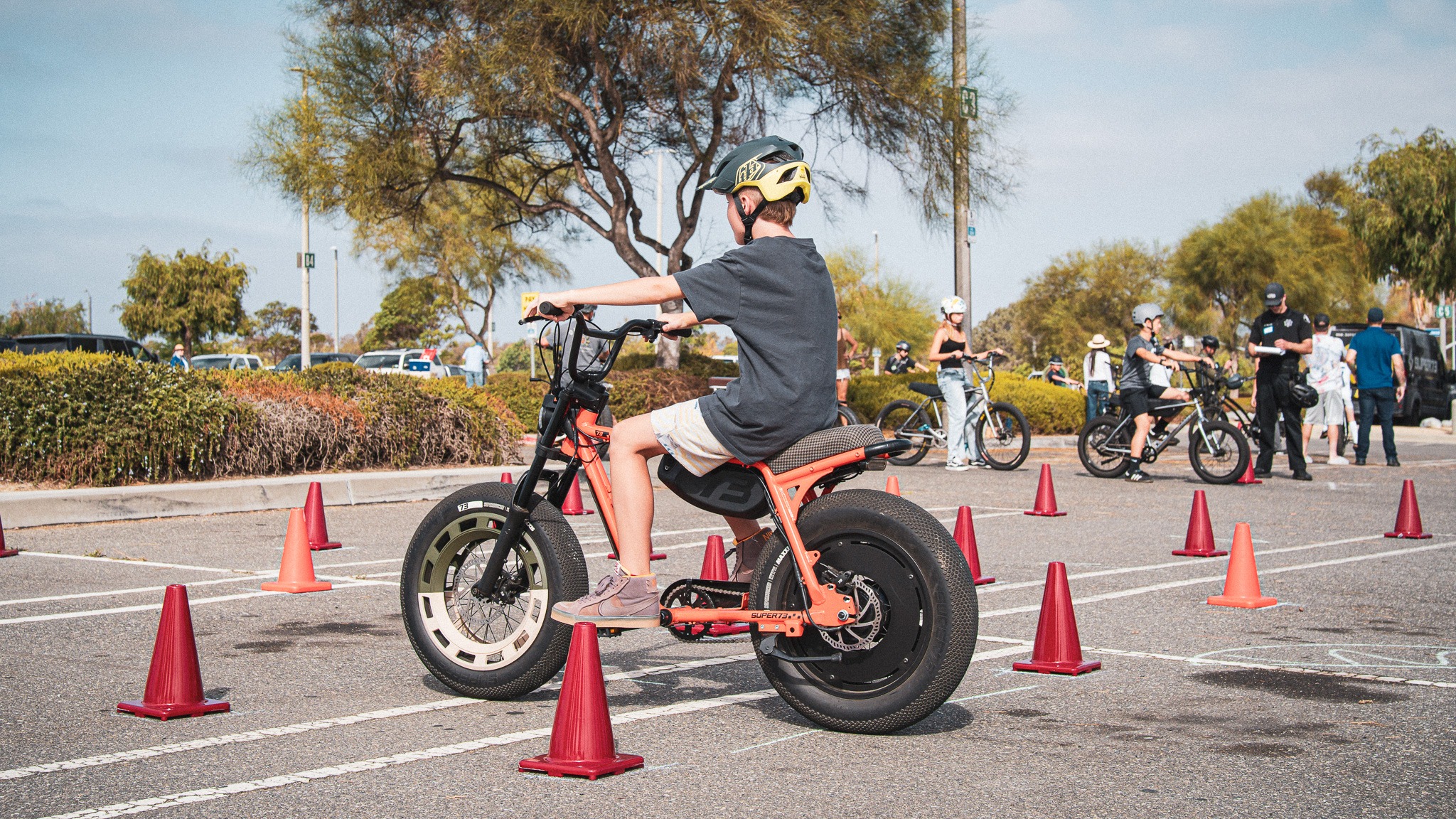 A helmeted young rider navigating a marked cone course during eBike training