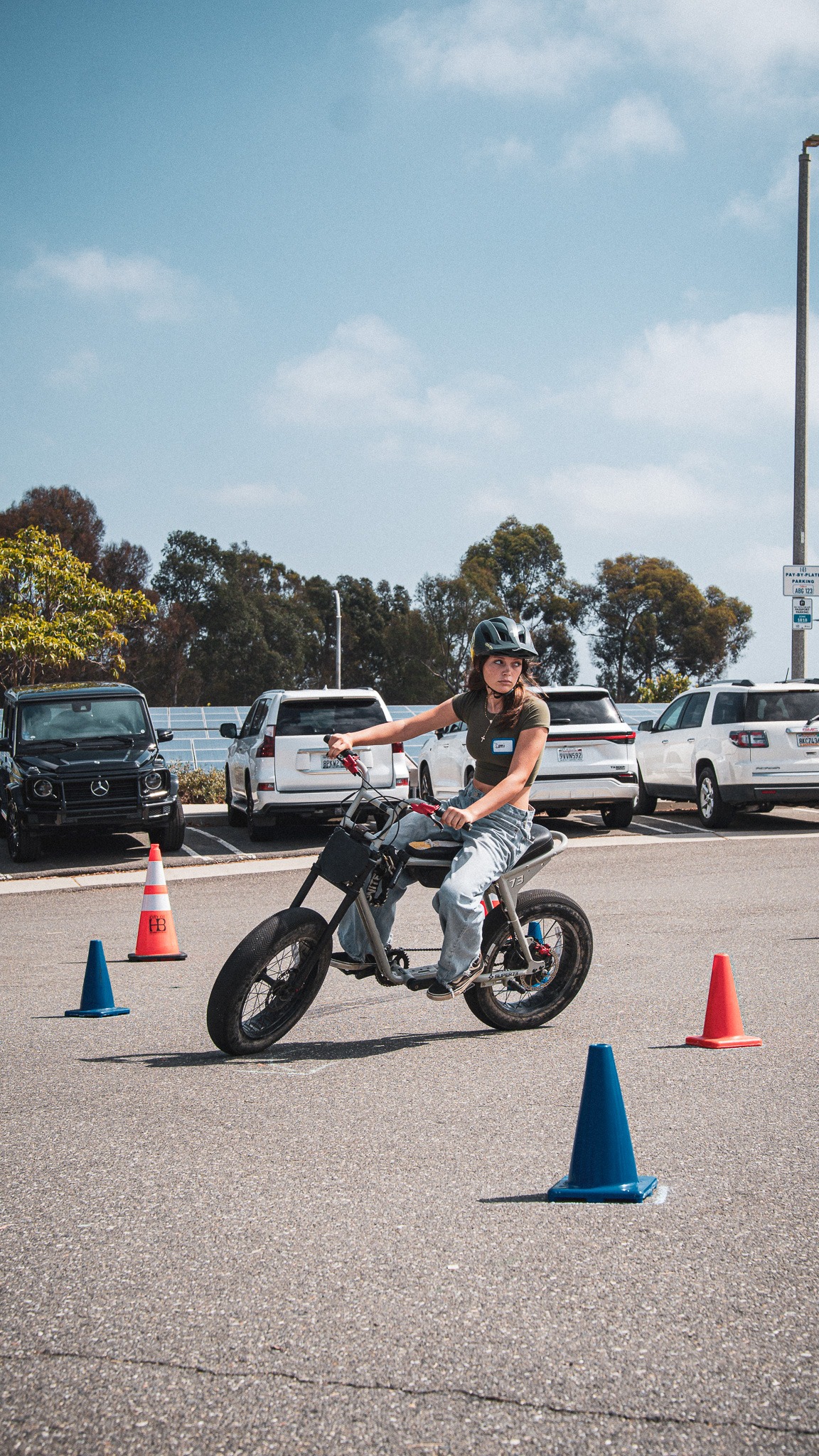 A helmeted young rider looking through a turn during a coned skills exercise